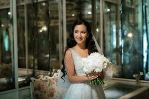 portrait de une la mariée dans une blanc robe dans une brillant café photo