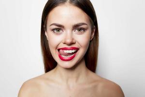 femme avec à nu épaules rouge lèvres montrant langue grimace studio photo