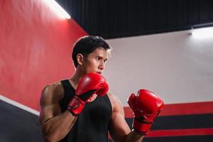 portrait de fort Jeune athlète sportif muay thaïlandais boxeur combat dans salle de sport, musclé Beau boxe homme combattant photo