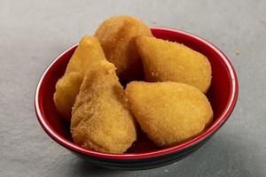 traditionnel frit coxinha dans assiette sur ardoise arrière-plan, populaire brésilien casse-croûte photo