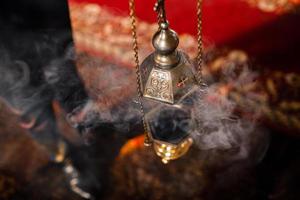 un encensoir de prêtre est suspendu à un vieux mur de l'église orthodoxe. encens de cuivre avec du charbon brûlant à l'intérieur. service dans le concept de l'église orthodoxe. adoration. photo