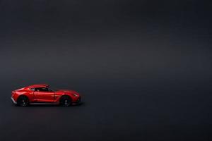 une photo de une rouge jouet voiture sur isolé noir arrière-plan, après certains modifications.