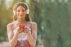 transgenres femme écoute à la musique avec le mobile en plein air photo