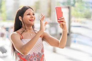 trans femme agitant à le mobile tandis que Faire vidéo appel photo