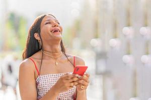 portrait de une trans femme en riant et en utilisant le mobile photo