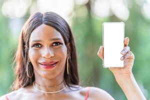 transgenres femme montrant le écran de le mobile tandis que souriant photo