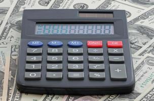calculatrice sur tas de un cent dollars billets de banque photo
