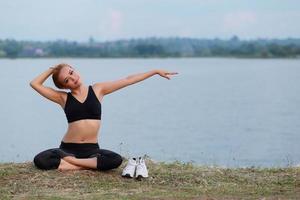 Jeune fille Faire yoga aptitude exercice Matin lever du soleil Extérieur dans le Prairie magnifique montagnes paysage. méditation et se détendre. photo