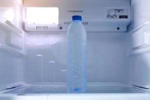 du froid en buvant l'eau bouteilles dans le réfrigérateur photo