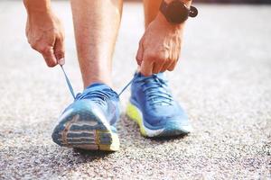 chaussures de course. gros plan sur une athlète féminine attachant des lacets pour faire du jogging sur la route. les liens du coureur se préparent pour l'entraînement. style de vie sportif. copier la bannière de l'espace. photo