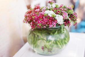 bouquet rose fleurs dans verre pot et l'eau dans verre vase. photo