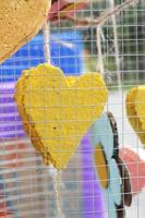 Jaune mousse cœur formes pendaison dans câble cage décorer dans mariage l'amour jardin. valentines journée concept. photo