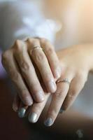 jeune marié mains en portant la mariée mains avec mariage bague dans thaïlandais mariage la cérémonie traditionnel. photo