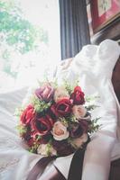 magnifique Rose fleurs bouquet sur mariage robe la mariée sur ancien chaise . Valentin journée photo