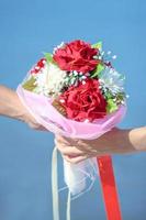 couple l'amour main en portant magnifique des roses fleurs bouquet. Valentin journée et mariage la cérémonie concept photo