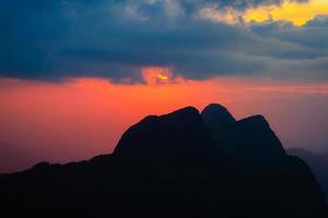 le coucher du soleil dans ciel et nuage, magnifique coloré crépuscule temps avec silhouette de Montagne. photo