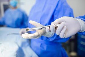 tir à faible angle dans la salle d'opération, l'assistant distribue des instruments aux chirurgiens pendant l'opération. les chirurgiens pratiquent l'opération. médecins professionnels pratiquant la chirurgie. photo