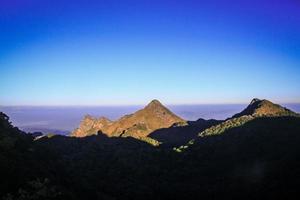 lever du soleil dans Matin avec ciel et nuage sur le calcaire Montagne. rayon du soleil avec brouillard et brouillard couverture le jungle colline dans Thaïlande photo