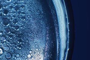 abstrait lumière bleu Contexte avec pétrole cercles . bulles de l'eau proche en haut . pétrole bulles dans le l'eau macro. cercle bulles Contexte photo