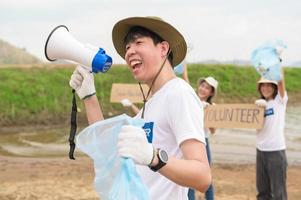 bénévoles de le asiatique jeunesse communauté en utilisant ordures Sacs nettoyage en haut la nature par photo