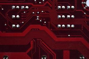 Gros plan de puces de carte mère d'ordinateur rouge avec des contacts