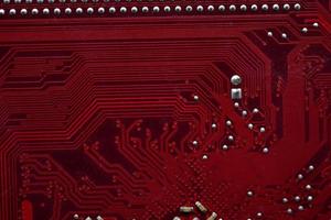 Gros plan de puces de carte mère d'ordinateur rouge avec des contacts