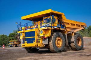 lourd Jaune ouvert jeter mien déverser camions à réparation station à ensoleillé sans nuages journée photo