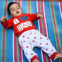 mignonne peu Indien bébé séance profiter Extérieur tirer à société parc dans Delhi, mignonne bébé garçon séance sur coloré tapis avec herbe autour, bébé garçon Extérieur tirer photo