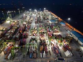 Jakarta, Indonésie 2021- Vue aérienne du chargement et du déchargement de porte-conteneurs dans un port en haute mer, importation logistique et transport de marchandises à l'exportation par porte-conteneurs en pleine mer la nuit