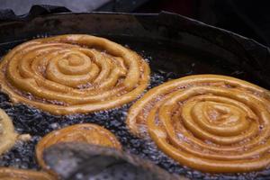 délicieux grincheux sucré Jalebi frit dans le cuisine la poêle sur une rue nourriture marché dans chakbazar, Dhaka, Bangladesh photo