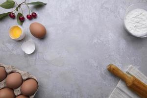 Ingrédients cuisson farine des œufs roulant épingle baies cuisine textiles sur gris Contexte. biscuit tarte ou gâteau recette maquette. en train de préparer pour culinaire pâtisserie. photo