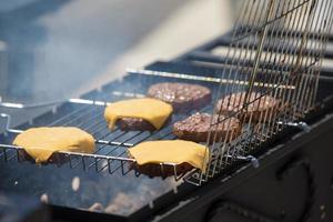 Hamburger galettes avec fromage sont grillé.grillé Viande. une pièce de Viande dans le fumée. photo