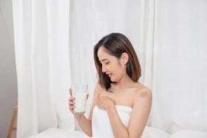 portrait de Jeune de bonne humeur asiatique femme en buvant en bonne santé Lait sur le Matin de le vacances bien du repos et en bonne santé mode de vie concept. photo