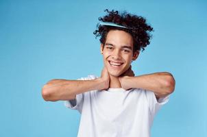 une homme avec une peigne dans le sien cheveux faire des gestes avec le sien mains sur une bleu Contexte copie espace photo