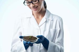 de bonne humeur femme dans blanc manteau étudiant science biotechnologie les plantes photo