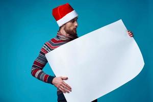 émotif homme dans une Père Noël chapeau en portant une bannière vacances studio posant photo