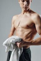 gars avec pompé en haut corps avec serviette dans mains tondu vue de bodybuilder photo