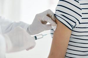 le médecin injecte le vaccin dans le les patients main photo