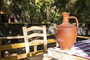 le argile cruche sur une en bois table dans le jardin. traditionnel Fait main argile cruche. ancien style. photo