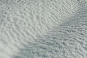 texture de neige. neige fond dans printemps. vagues sur surface. Naturel Contexte est l'hiver. photo