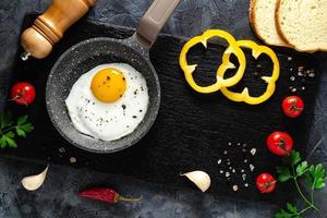 frit des œufs dans une friture la poêle avec Frais des légumes et épices. concept pour menu et publicité. photo