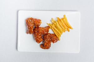 épicé chaud buffle ailes et français frites avec blanc sauce sur blanc assiette isolé blanc Contexte. Haut vues. photo