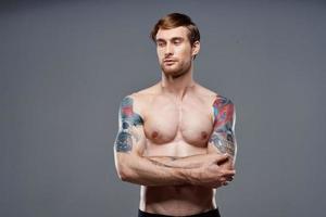 sport homme tondu vue faire des exercices tatouage sur bras gris Contexte photo