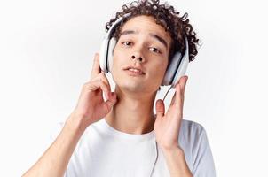 une homme dans une blanc T-shirt avec écouteurs écoute à la musique émotions joie jouissance photo