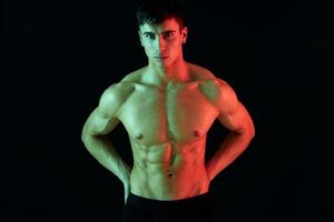 difficile Couper avec pompé muscles bodybuilder aptitude athlétique physique néon lumière noir Contexte photo