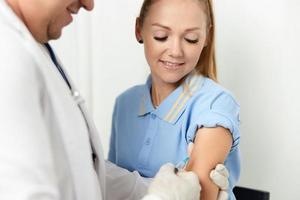 le médecin fait du un injection dans le main de une hôpital santé patient vaccination photo