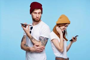 Jeune couple dans Chapeaux avec Téléphone (s dans mains mode la communication photo