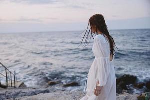 femme dans blanc robe posant océan Voyage été inchangé photo