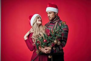 portrait de une Jeune couple dans un embrasse vacances Noël rouge Contexte photo
