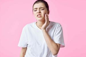 femme dans blanc T-shirt en portant sa cou douleur problèmes rose Contexte photo
